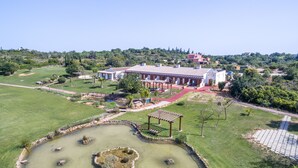 A large estate with a central building, a pond, and surrounding landscaped areas. - Quinta dos Poetas Nature Hotel & Apartments (Olhao)