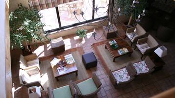 An indoor seating area with wicker furniture, a coffee table, and a potted plant.