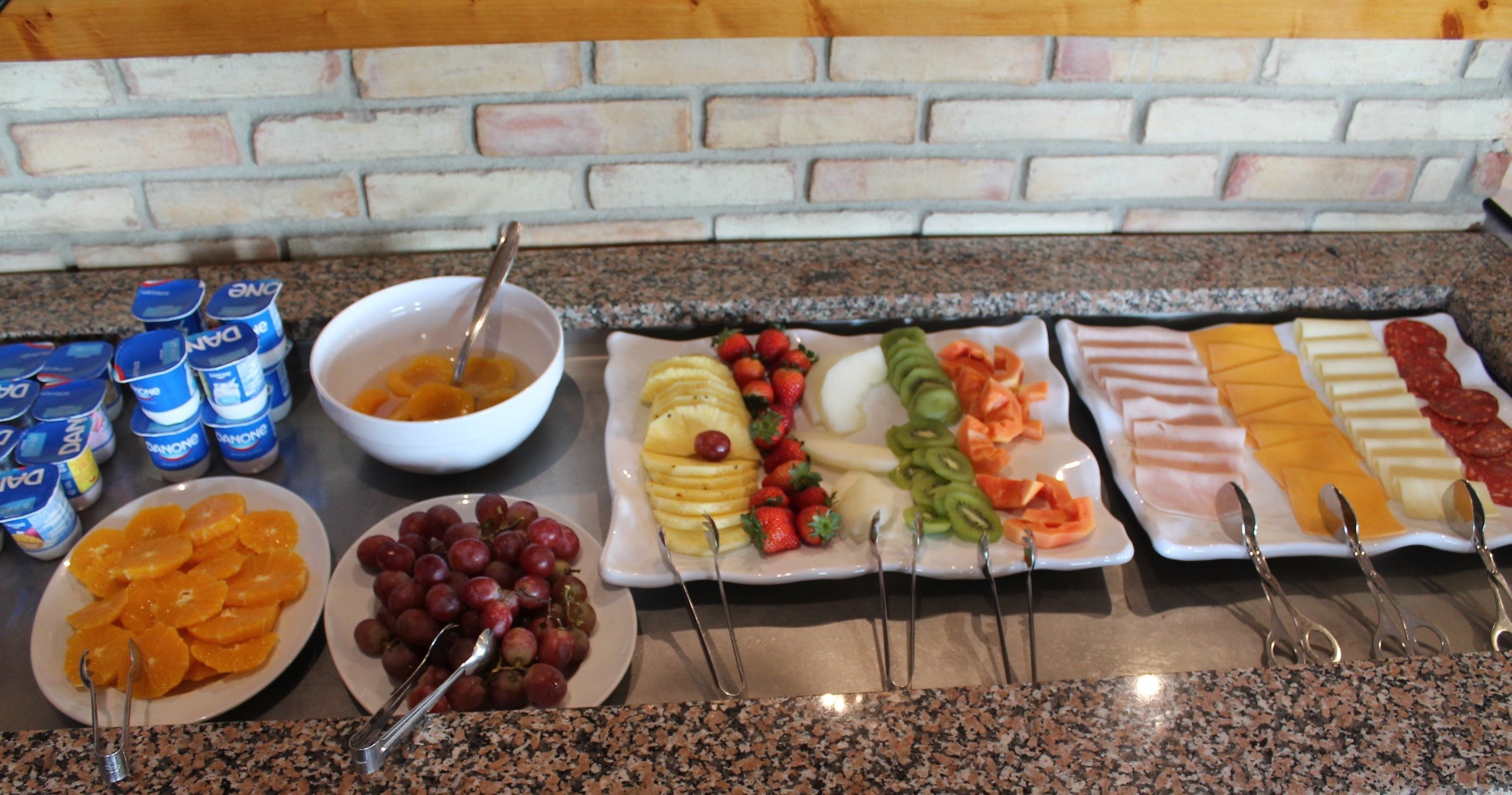 A buffet with various fruits and cheeses.