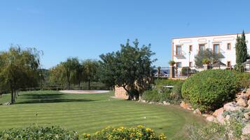 Enjoy a round of golf in a well-manicured course surrounded by lush trees and beautifully maintained hedges.