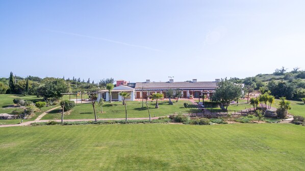A large, single-story building with a tiled roof and a covered patio area.