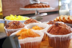 Una selezione di muffin in coppette di carta su un tavolo di legno.