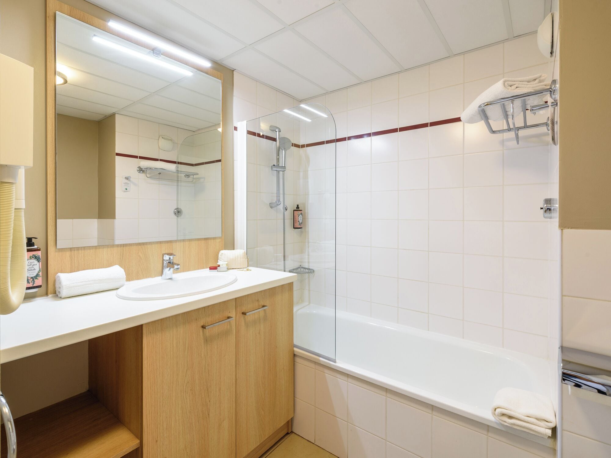 Un baño moderno con un espejo grande, dos lavamanos, ducha y bañera.