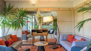 A modern lobby with two sofas, a coffee table, and a reception desk. - Residhome Toulouse Occitania (Toulouse)