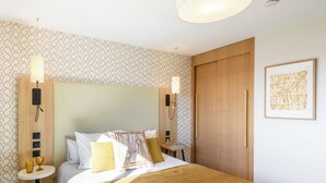 A hotel room with a bed, bedside tables, a wardrobe, and a framed artwork on the wall. - Residhome Toulouse Occitania (Toulouse)