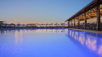 En säsongsöppen utomhuspool, parasoller och solstolar