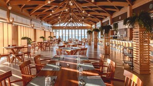 A spacious restaurant with high wooden ceilings and natural light. Tables are set with placemats and cutlery. - Arina Beach Resort - All inclusive (Hersonissos)