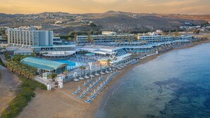An aerial view of a coastal hotel with multiple swimming pools, sun loungers, and a beach area. - Arina Beach Resort - All inclusive (Hersonissos)