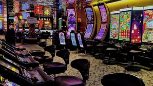 Un casino con máquinas tragamonedas, mesas de juego y zonas de estar cómodas.