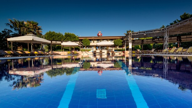 A hotel with a swimming pool, sun loungers, and umbrellas. - Avalon Airport Hotel Thessaloniki (Thermi)