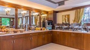 A spacious kitchen with wooden cabinets, a large breakfast bar, and a coffee station. - Avalon Airport Hotel Thessaloniki (Thermi)