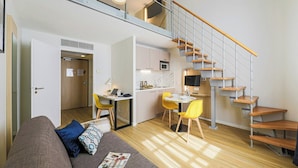 Un apartamento moderno con un dormitorio en loft, comedor y cocina.