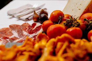 A variety of food items including tomatoes, garlic, and cheese on a table. - Hotel Can Batiste (Sant Carles de la Rapita)