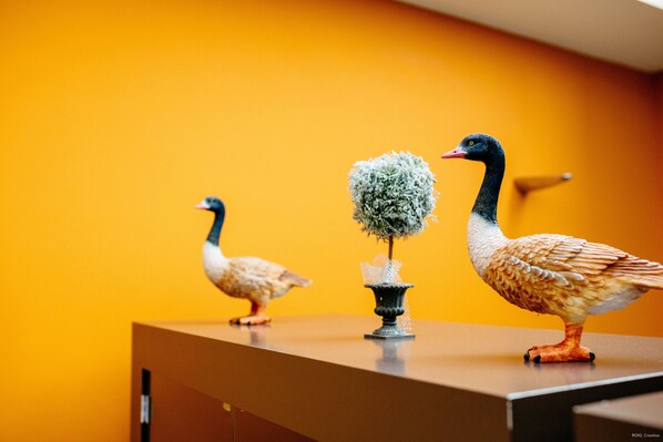 Tres aves decorativas sobre una encimera con fondo amarillo.