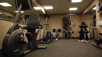 A gym with stationary bikes, elliptical machines, and weightlifting equipment.