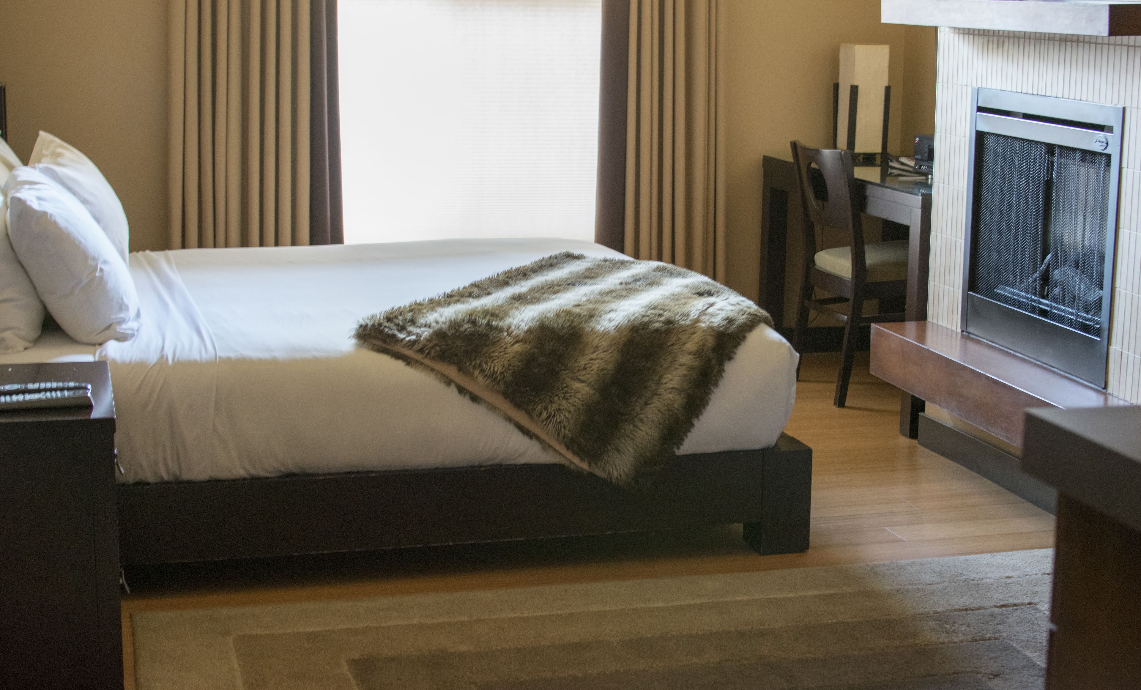 A hotel room with a bed, a desk, and a television.