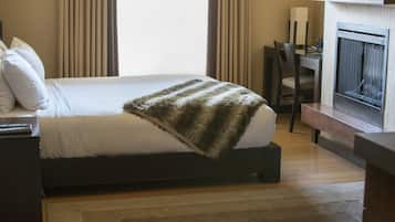 A hotel room with a bed, a desk, and a television.