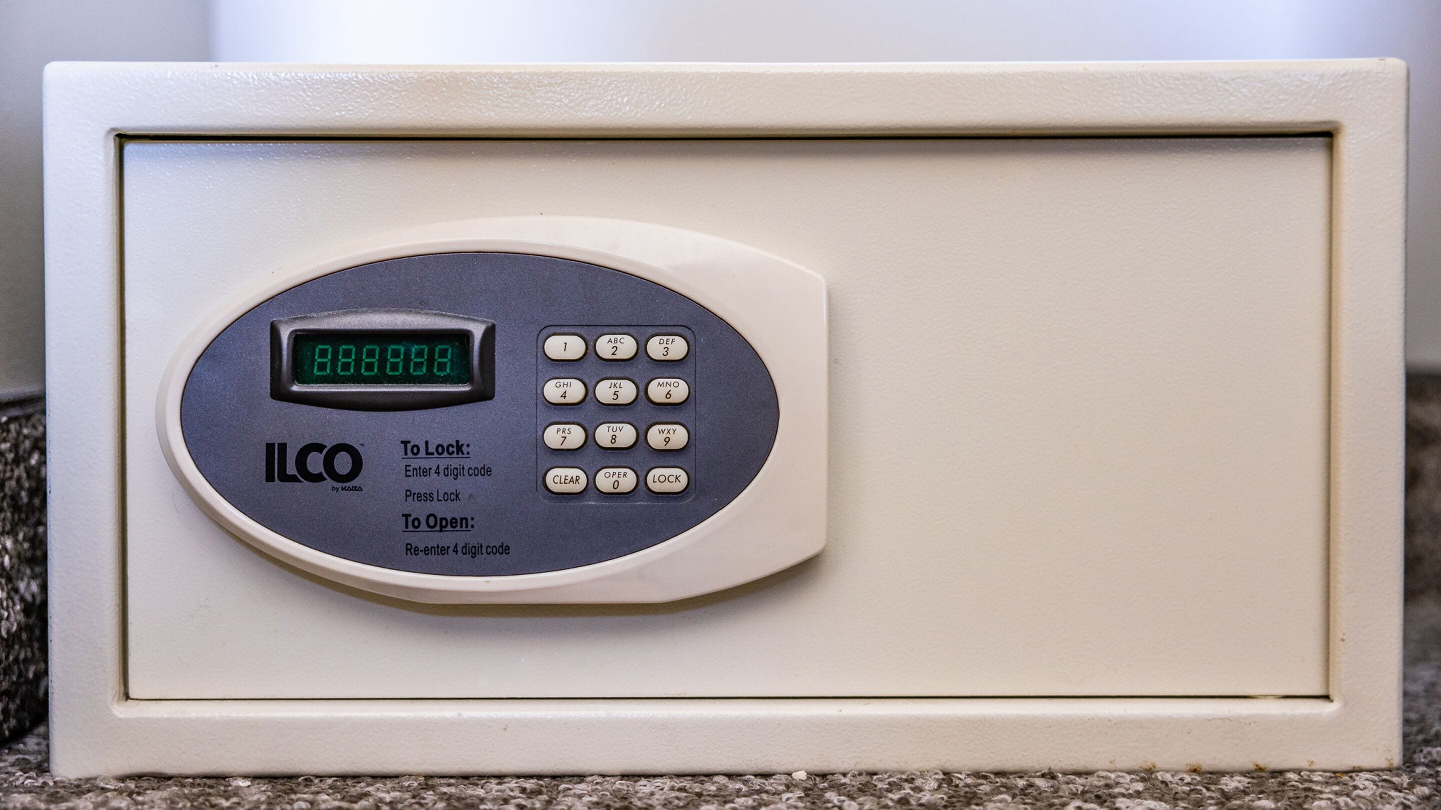 Et digitalt pengeskab med et tastatur og et display, der viser '888888'. Instruktioner for låsning og oplåsning er synlige.