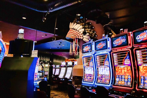 A casino with multiple slot machines, a large decorative structure, and a bar area.