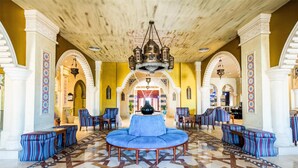 A lobby with a central blue sofa, patterned floor, and arched doorways. - Sunrise Sentido Mamlouk Palace - All inclusive (Hurghada)