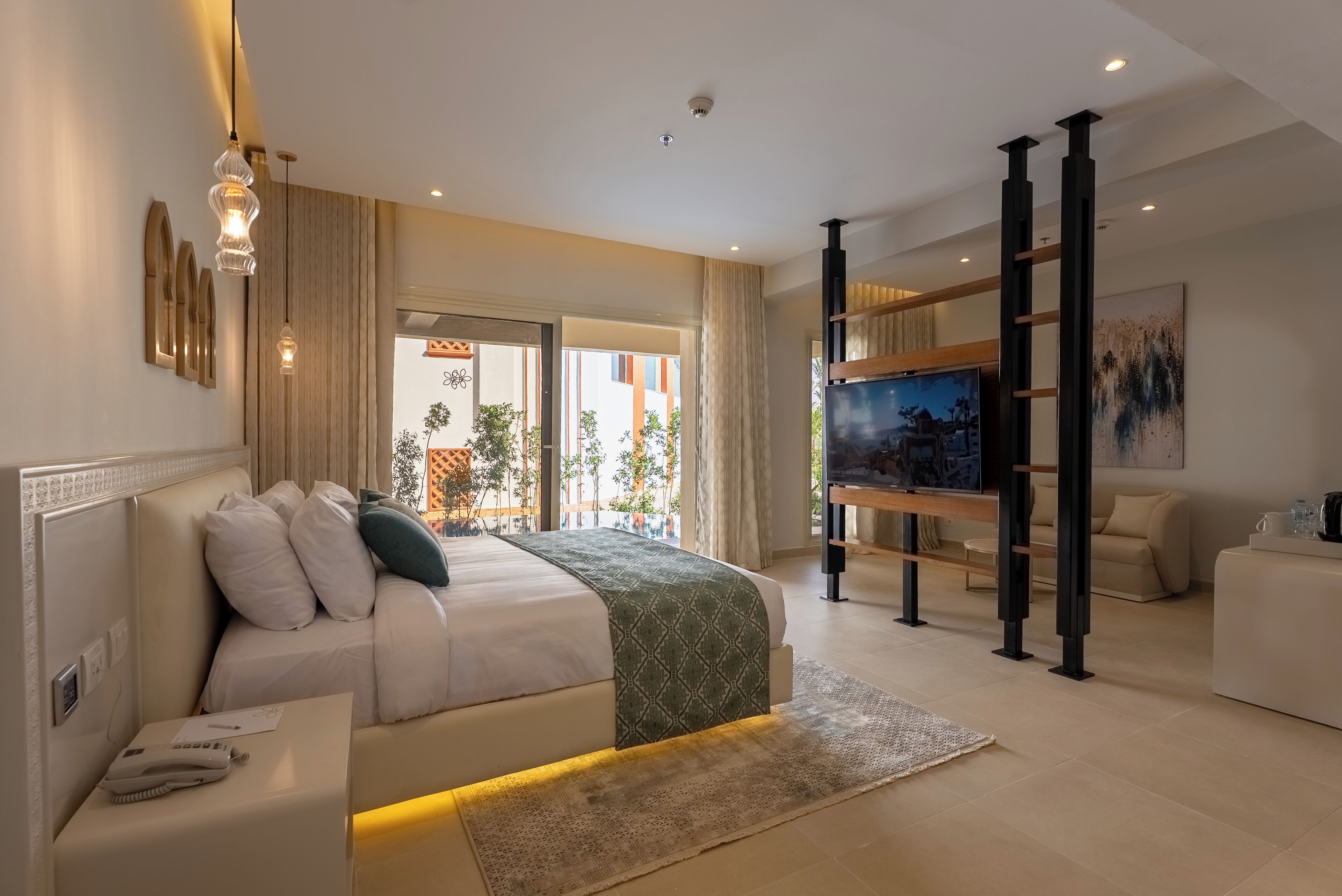 Une chambre d’hôtel moderne avec un grand lit, une télévision, une échelle en bois et une vue sur l’extérieur.