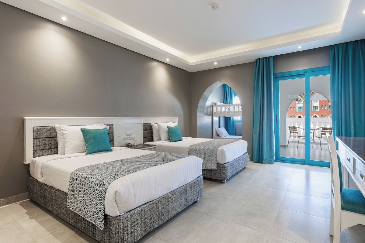 A hotel room with two beds, a balcony with a view, and a modern design.