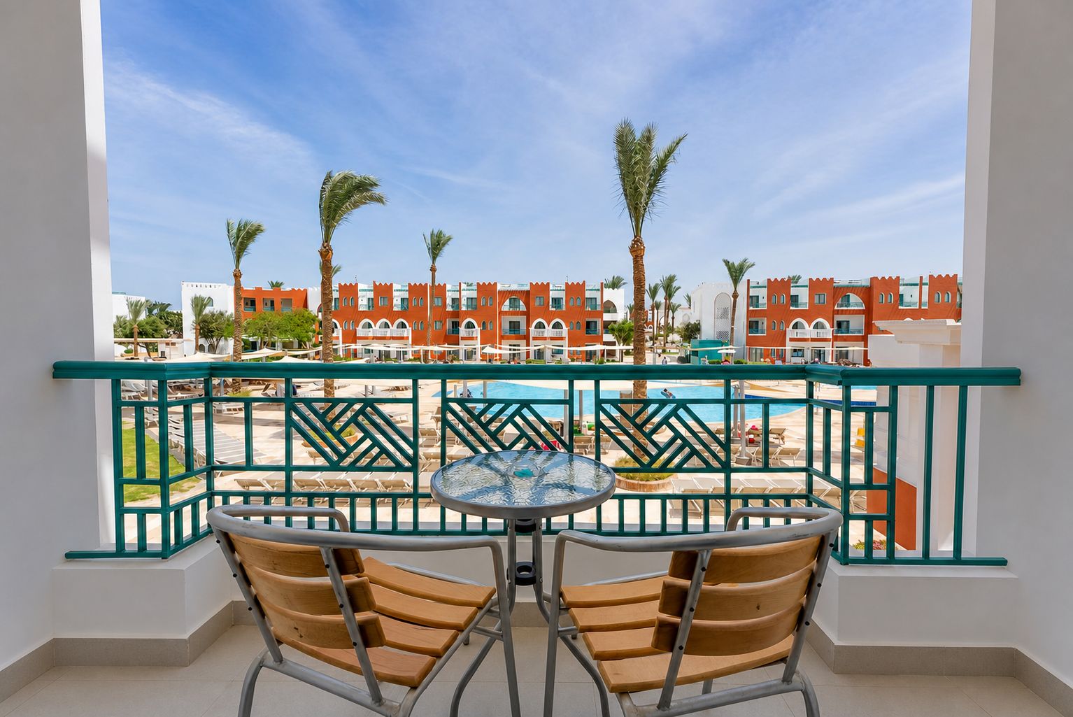 Un balcon avec vue sur une piscine et les bâtiments du complexe hôtelier.