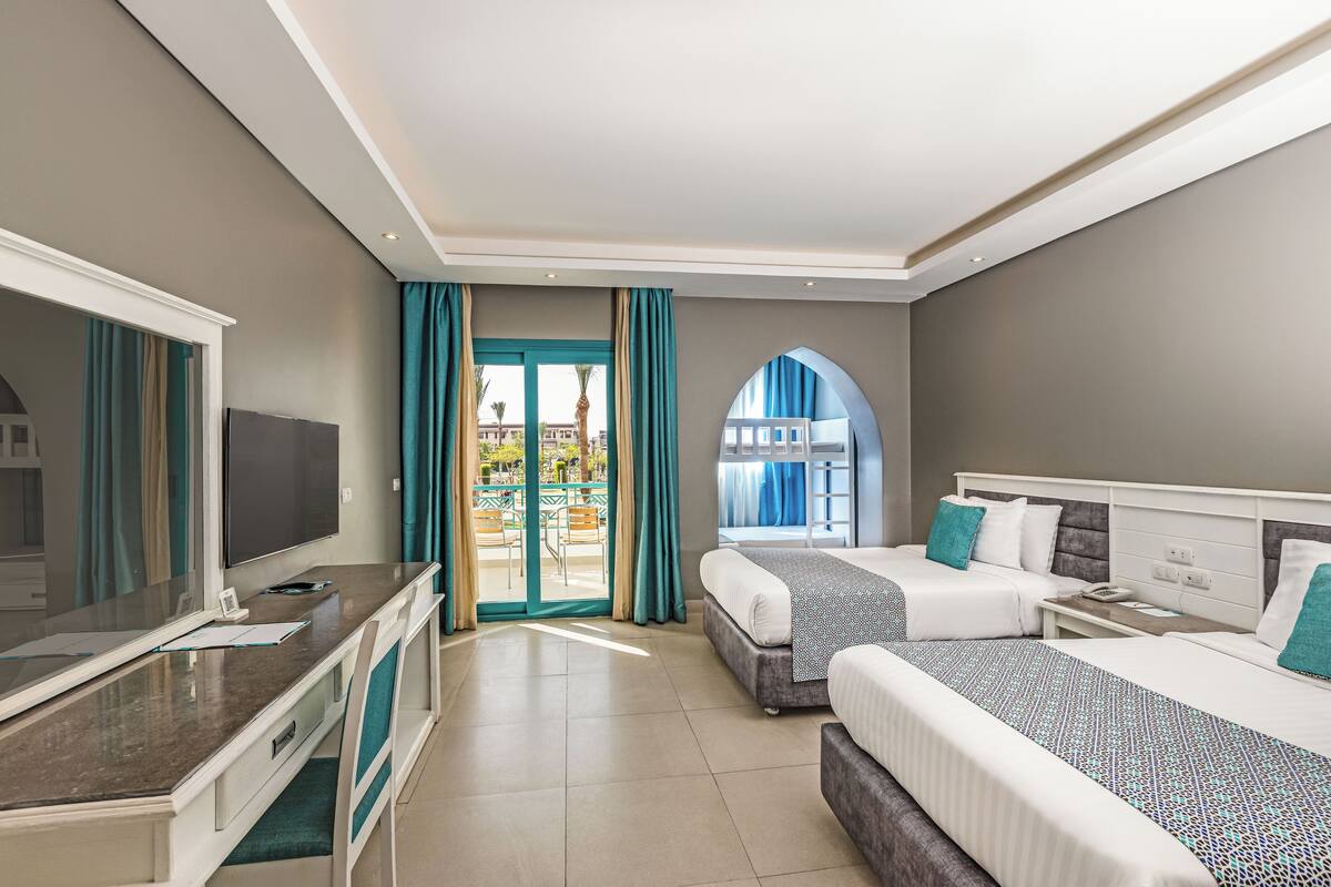 Una habitación de hotel con dos camas, un escritorio y televisión.
