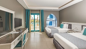 Ein Hotelzimmer mit zwei Betten, einem Schreibtisch und einem Fernseher.