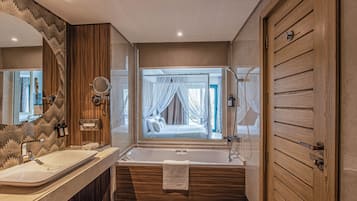 A modern bathroom with a large bathtub, a double sink vanity, and a large mirror.