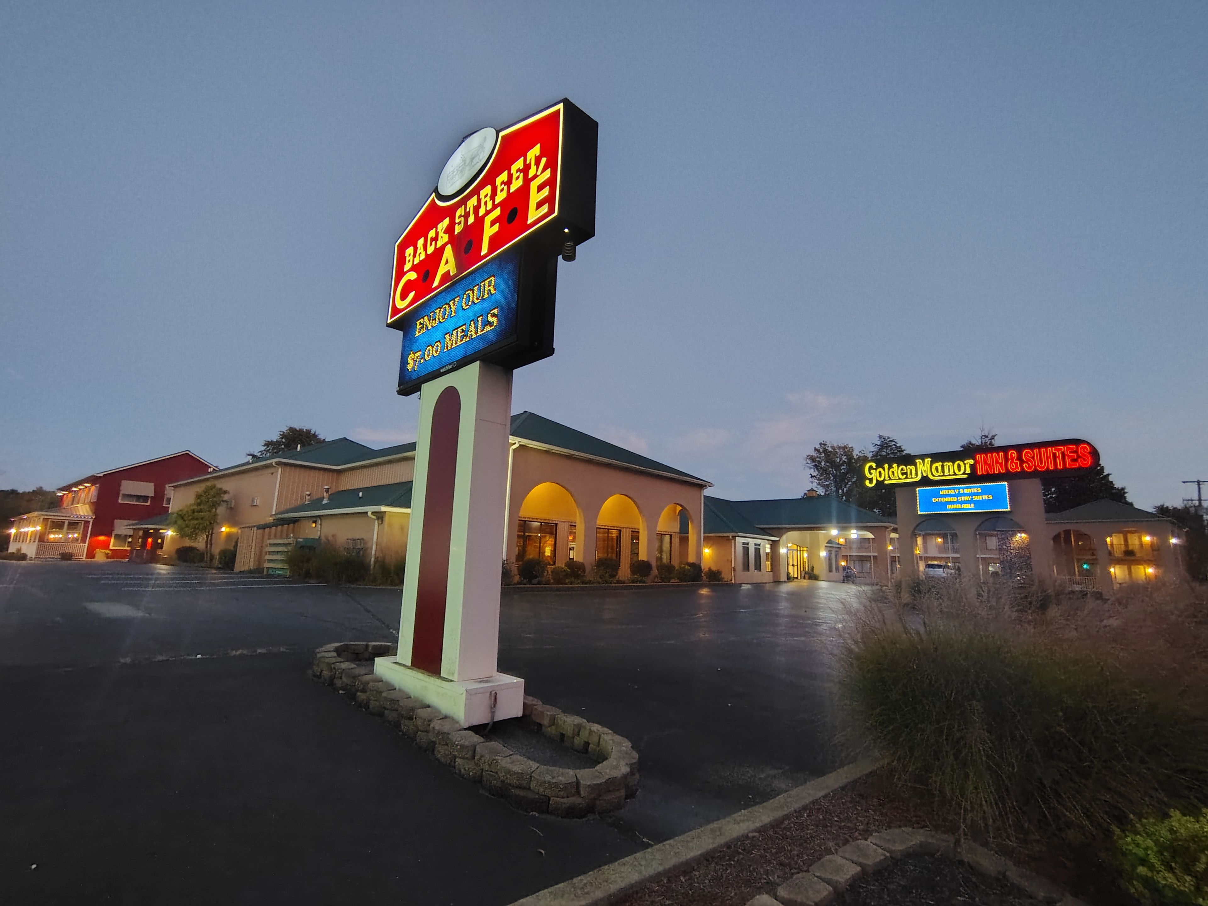 A hotel with a sign for a back street cafe offering $7.00 meals.
