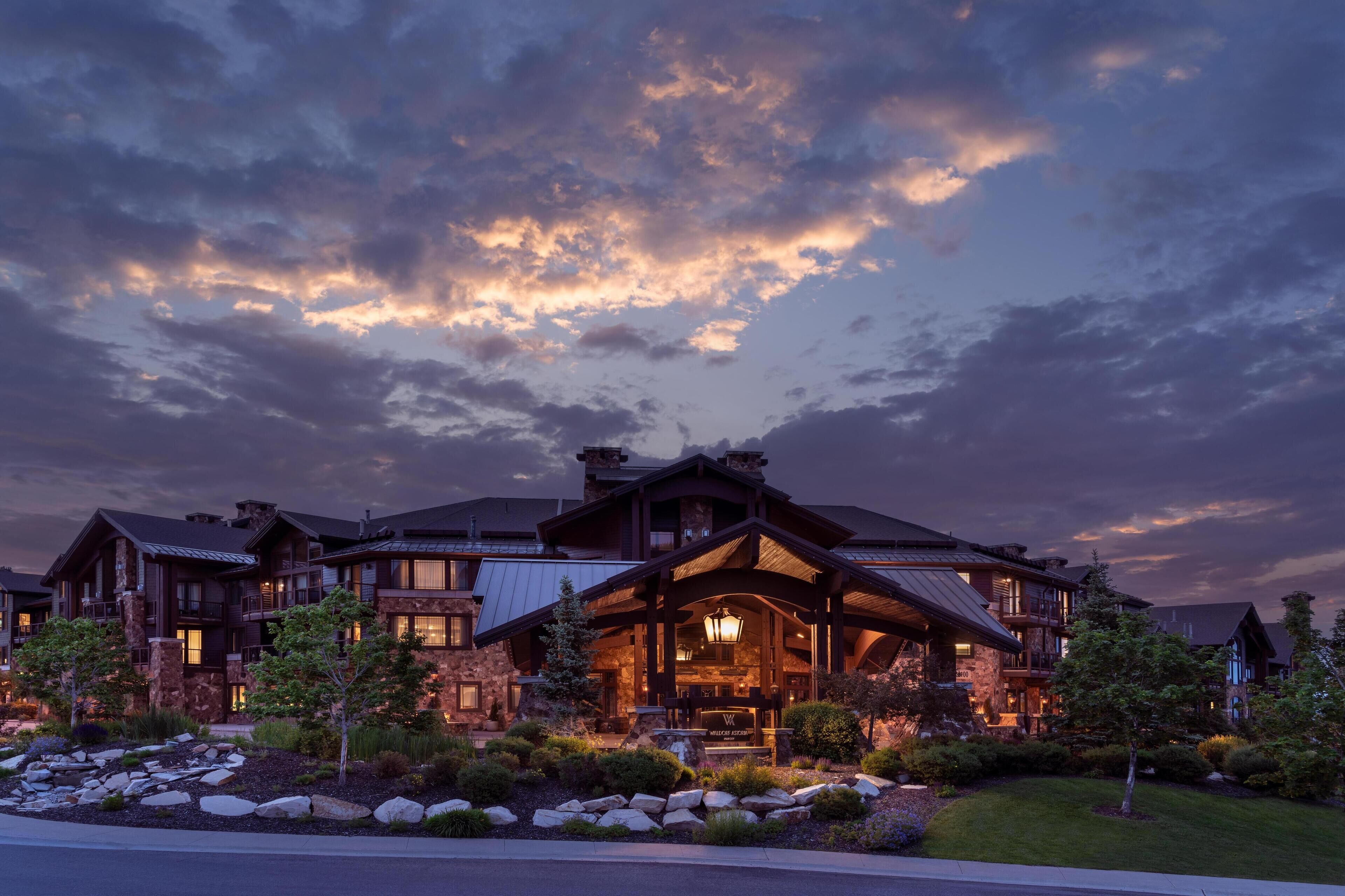 Un grand bâtiment de plusieurs étages, de style chalet, doté d’une entrée imposante et d’une façade bien éclairée.