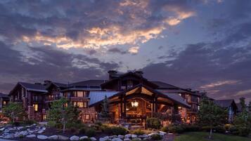 Un grand bâtiment de plusieurs étages, de style chalet, doté d’une entrée imposante et d’une façade bien éclairée.