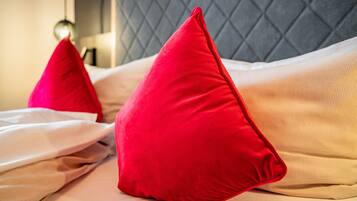 A bed with two red pillows and a grey headboard.
