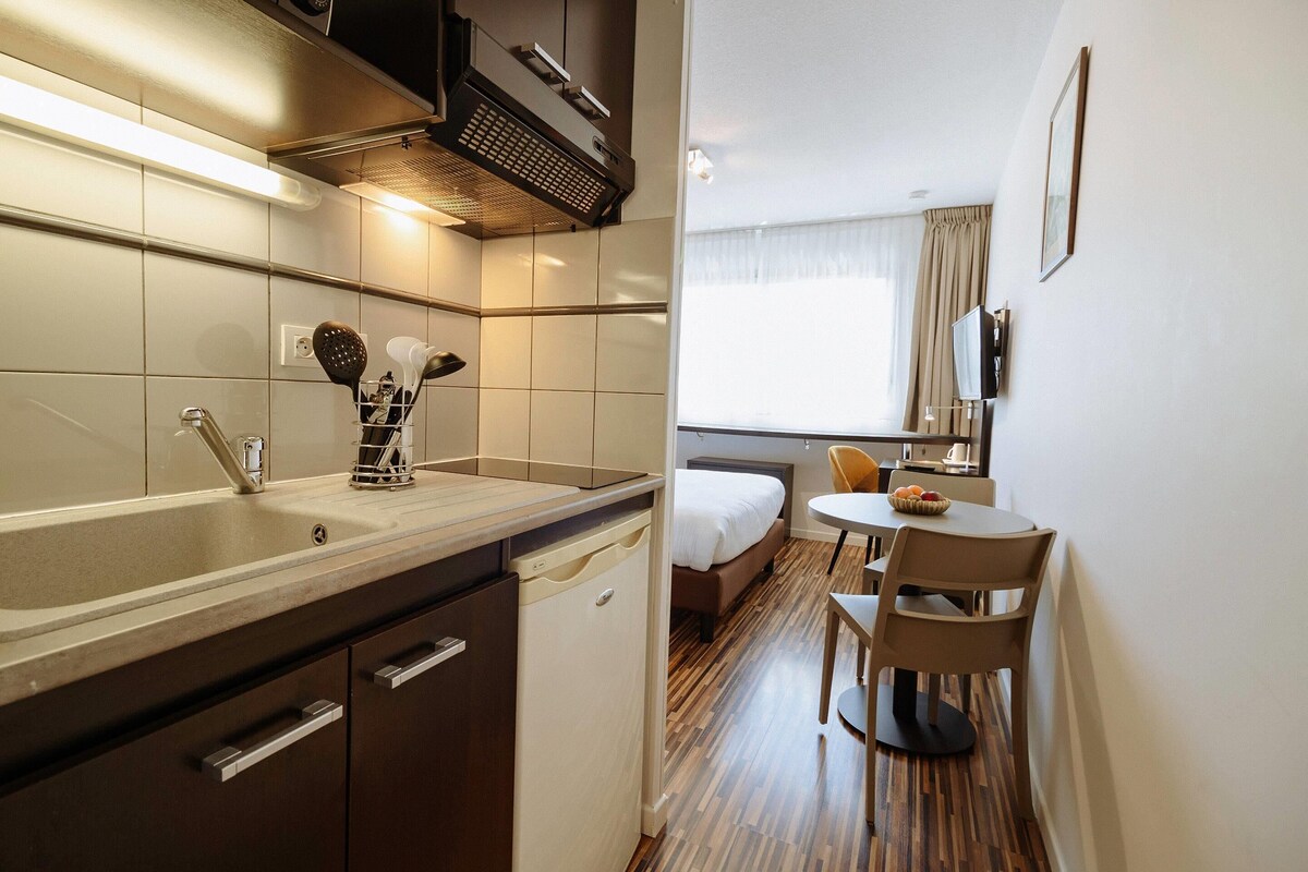 Een moderne keuken met een spoelbak, vaatwasser en een eethoek met een tafel en stoelen.