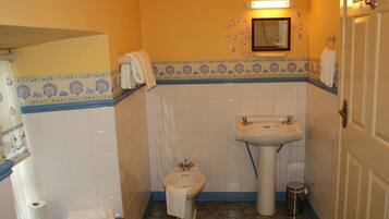 Un baño con inodoro, lavabo y un perchero para toallas.