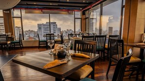 Ein Restaurant mit Blick auf die Stadt, Holztische und -stühle.
