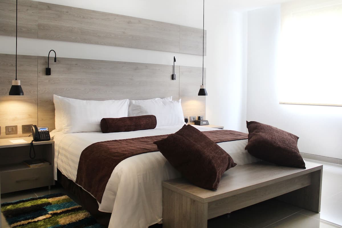 Ein modernes Schlafzimmer mit Bett, Nachttischen und einem Beistelltisch.