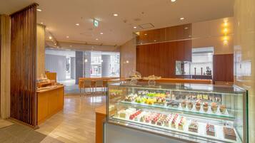 A modern cafe with a glass display case filled with pastries and a wooden counter area.