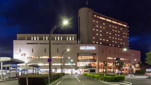 Un hotel de diseño moderno, con un llamativo letrero de Art Hotel, varios pisos y una entrada bien iluminada.