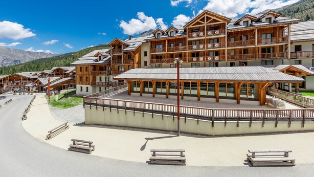 A wooden lodge with multiple balconies and a central open area, surrounded by mountains. - Noemys Les Chalets de Bois Méan (Les Orres)