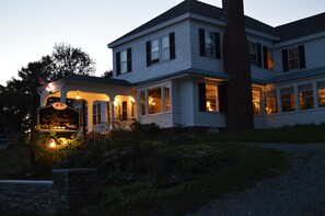 A two-story house with a porch and a sign that reads "The Brewster Inn."