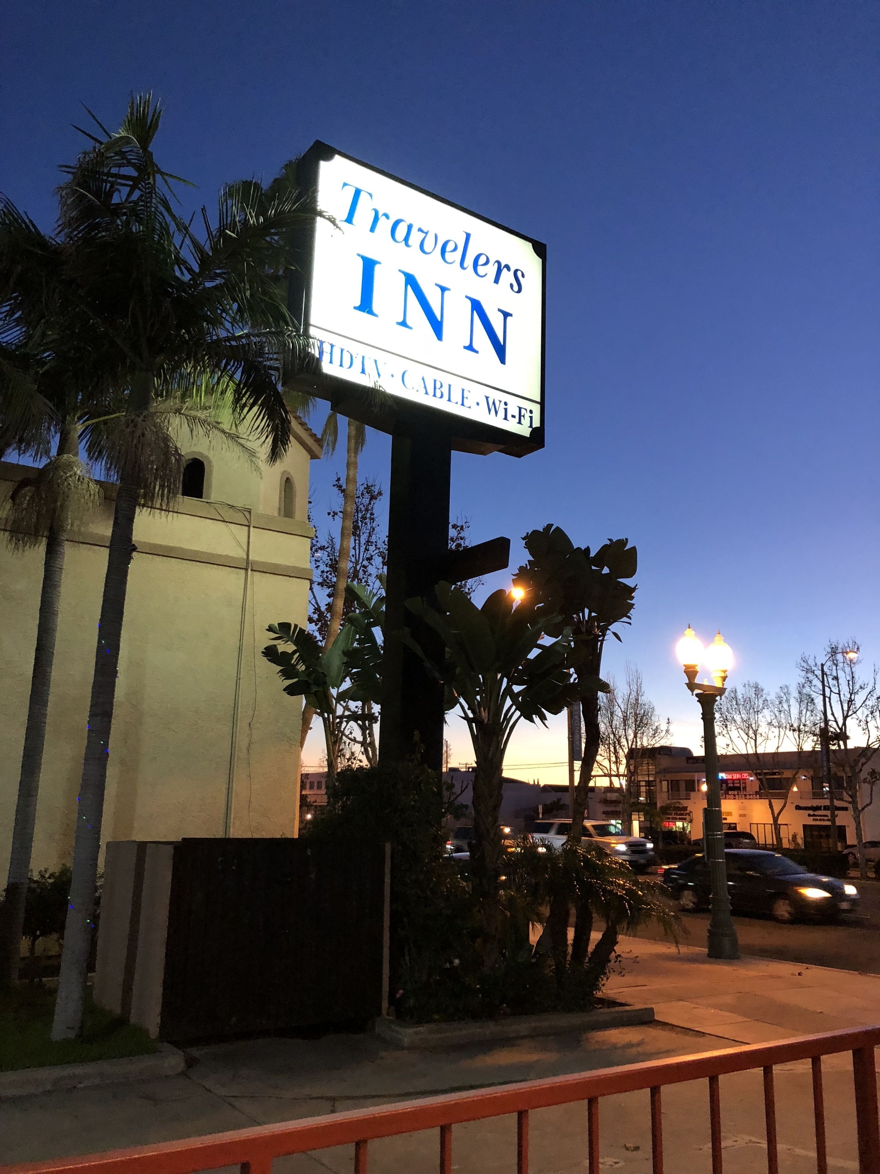 Señal de Travelers Inn que indica HDTV, cable y Wi-Fi.