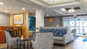 A lobby with a reception desk, seating area, and a clock on the wall. - Holiday Inn Express Hotel & Suites, a Lake Zurich-Barrington by IHG (Lake Zurich)