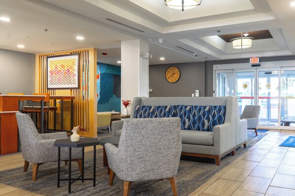 A lobby with a reception desk, seating area, and a clock on the wall. - Holiday Inn Express Hotel & Suites, a Lake Zurich-Barrington by IHG (Lake Zurich)