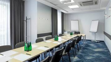 A conference room with a long table, chairs, a whiteboard, and a projector.