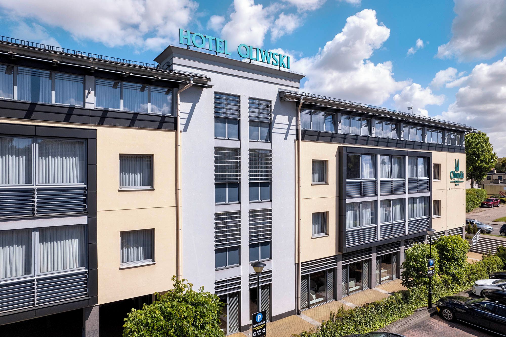 Ein mehrstöckiges Hotelgebäude mit großen Fenstern und einem Schild, das es als Hotel kennzeichnet.