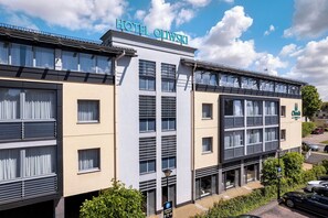 A hotel building with multiple floors, large windows, and a sign indicating it is a hotel. - Hotel Oliwski (Gdansk)