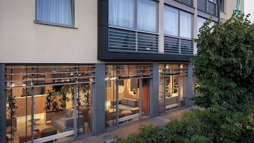 Un edificio moderno con amplios ventanales, un balcón y un interior luminoso.