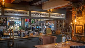 A bar area with a counter, various bottles, glasses, and a menu board. - Brackenborough Hotel, BW Signature Collection (Louth)